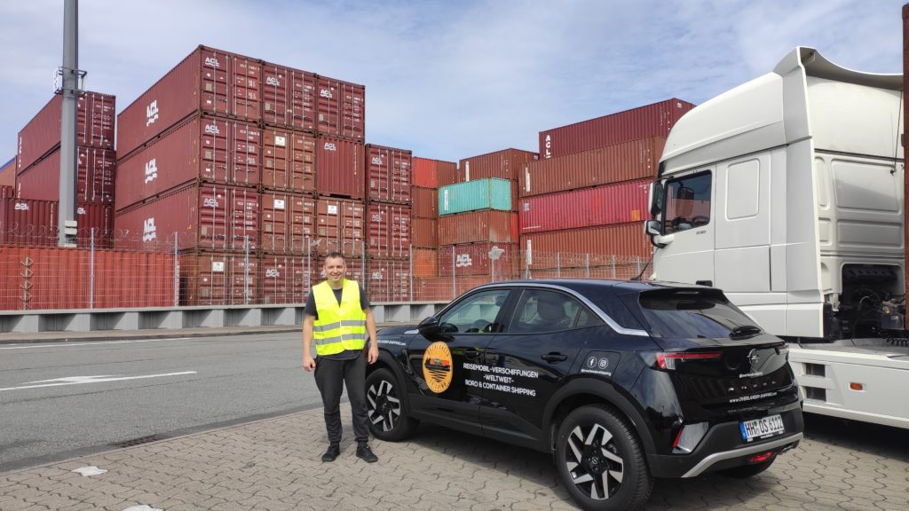 Super zufrieden mit dem Service von Overlander Shipping, im Hintergrund stapeln sich die Container im Hafen in Hamburg
