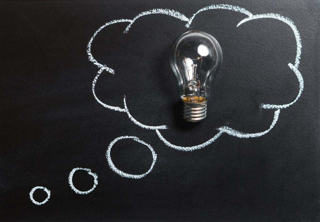 Lightbulb in a thought cloud on a blackboard