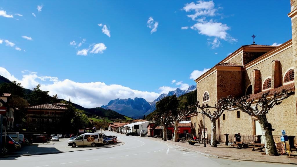 Potes con Iglesia Nueva de San Vicente y Picos de Europa en el fondo